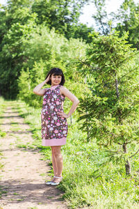 Portrait of woman standing by tree