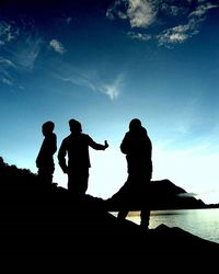 Silhouette people against blue sky