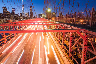 Blurred motion of cars on brooklyn bridge in city at night