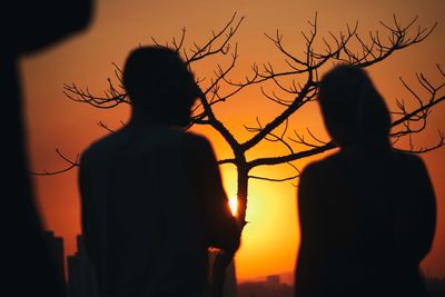 Rear view of silhouette couple against sunset sky