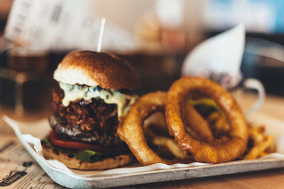 Close-up of burger and onion rings on table