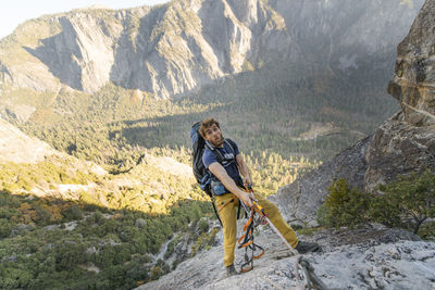 Man jugging rope up on el capitan doing funny face with backpack