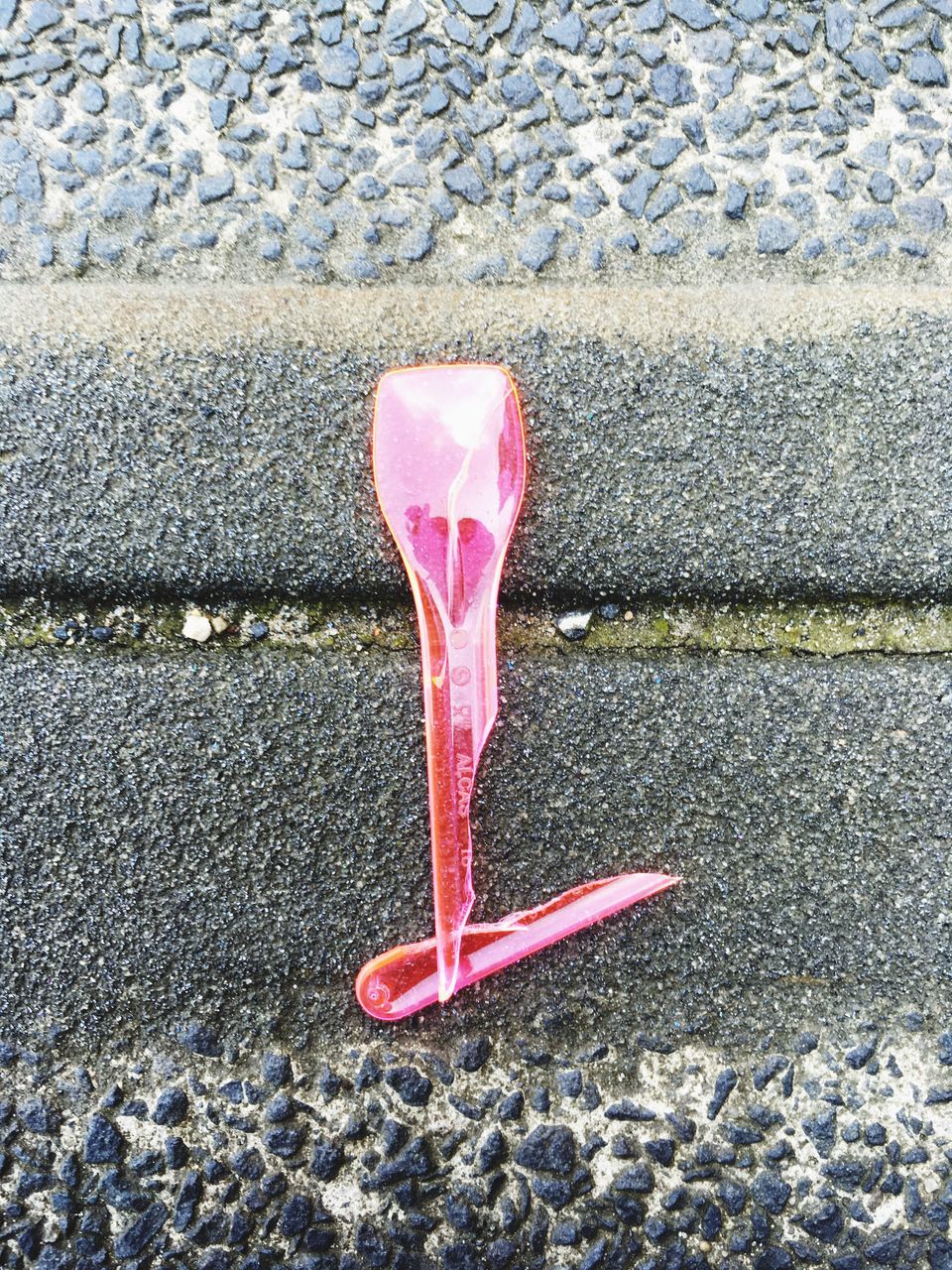 street, asphalt, red, road, high angle view, road marking, ground, still life, close-up, sidewalk, day, outdoors, transportation, textured, no people, cobblestone, single object, absence, sunlight, pink color