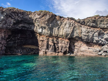 Rock formations by sea against sky