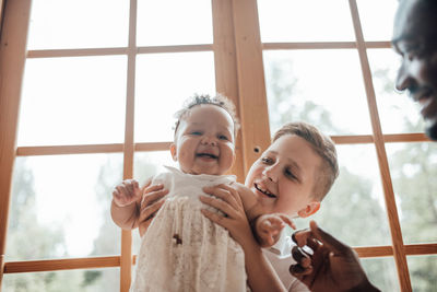 Rear view of mother and daughter against window