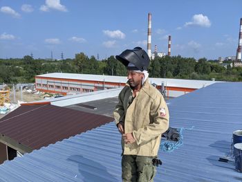 Full length of man standing by umbrella against sky