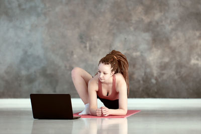 Side view of woman using mobile phone while sitting on table