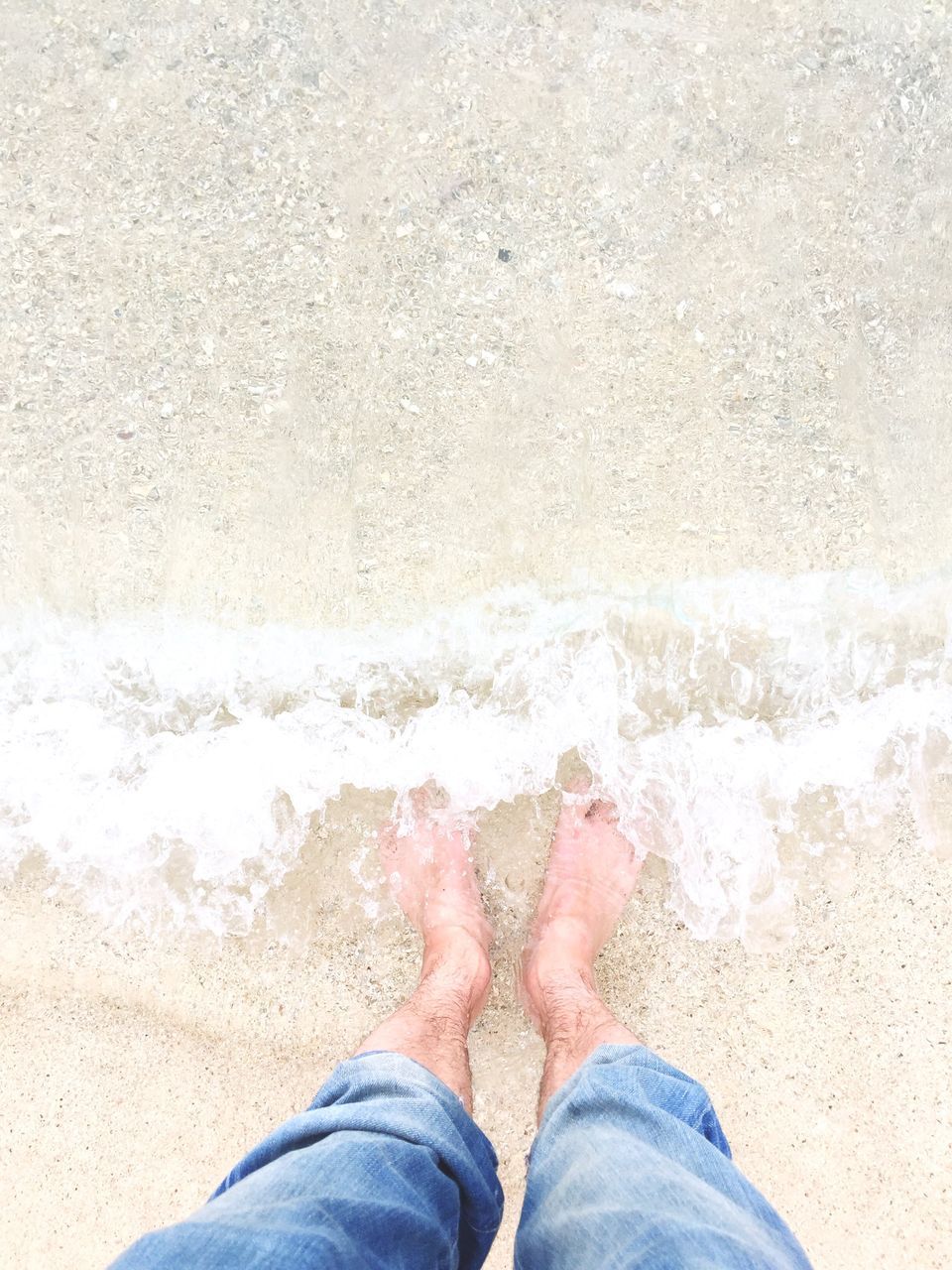 low section, person, personal perspective, human foot, sand, beach, lifestyles, shoe, standing, leisure activity, men, shore, barefoot, high angle view, jeans, water, day