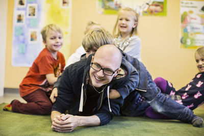 Teacher and children enjoying in kindergarten