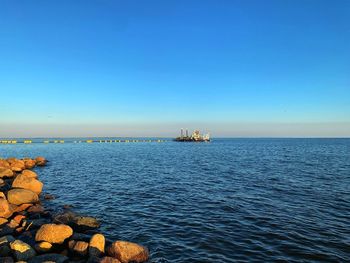 Scenic view of sea against clear blue sky