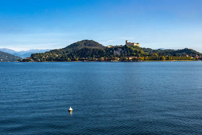 View of borromeo castle from arona waterfront on the shores of lake maggiore, piedmont, italy