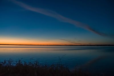 Scenic view of lake against sky at sunset