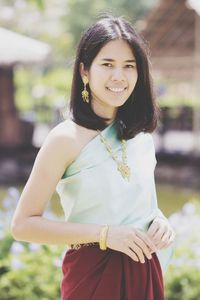 Portrait of smiling young woman standing outdoors