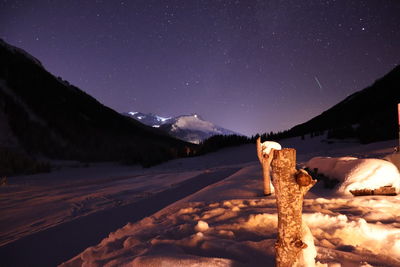 Scenic view of snowcapped mountains against sky at night