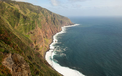 Scenic view of sea and mountains against sky