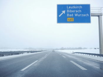 Road signs against sky during winter