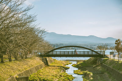 Arch bridge over river against sky