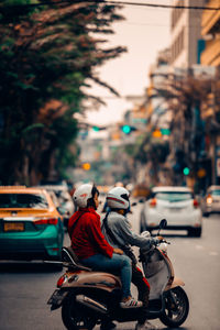 Man riding motor scooter on city street