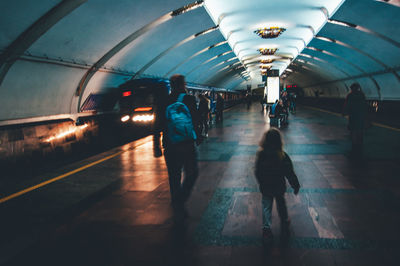 Rear view of people walking on subway station