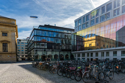 Buildings by street in city against sky