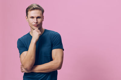 Portrait of young man standing against white background