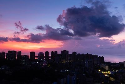 Illuminated buildings against sky during sunset
