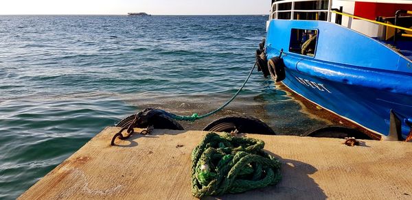 Boat moored at sea shore against sky