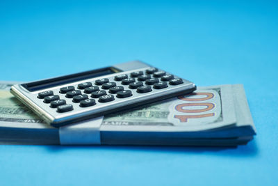 Close-up of computer keyboard on table against blue background