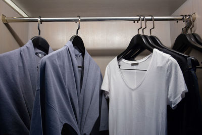 Close-up of clothes hanging on rack in shelf