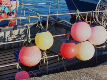 Colorful buoys hanging from boat railing