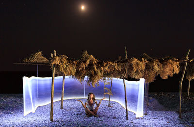 Boy on beach against clear sky at night