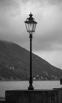 Street light against cloudy sky