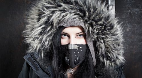 Close-up portrait of young woman wearing parka during winter