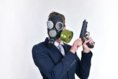 Well-dressed businessman wearing gas mask against white background