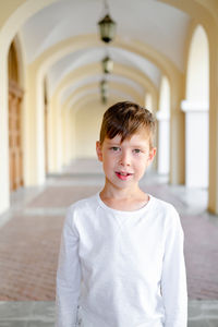 European boy in a white t-shirt on the street. portrait of a child with a closed aperture