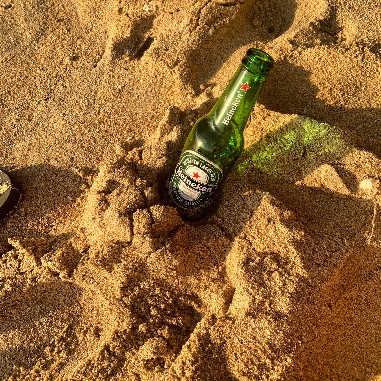 soil, bottle, sand, land, beach, sunlight, container, green, nature, high angle view, drink, alcohol, beer, refreshment, day, shadow, no people, outdoors, food and drink, brown