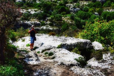 Full length of man standing by rock