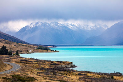 Scenic view of lake and mountains against cloudy sky