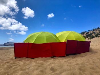 Umbrella on beach against blue sky