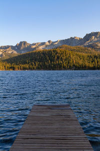 Scenic view of dock leading to a lake against clear sky