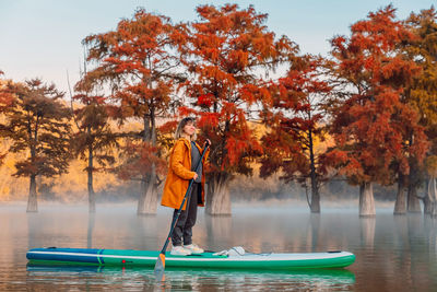 Rear view of woman standing in lake