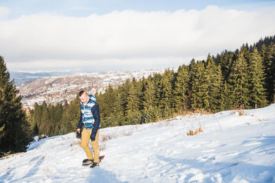 Man learning to snowboard during winter