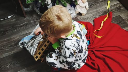 High angle view of boy playing with toy while sitting at home