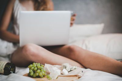 Grapes and bottle of white wine with cheese plate for the lunch in bedroom