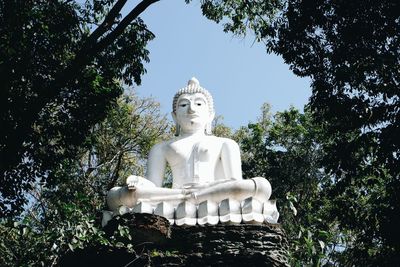 Low angle view of statue against trees