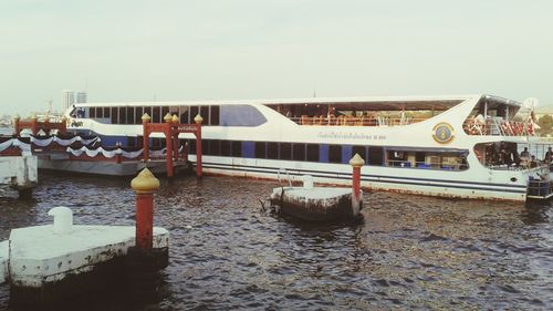 Boats moored at harbor against sky