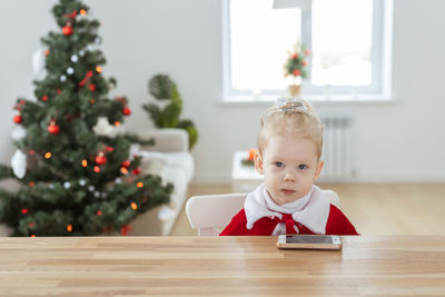 Portrait of cute girl sitting on table