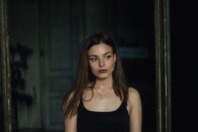 Woman looking away while standing in darkroom