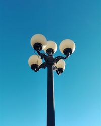 Low angle view of street light against clear blue sky