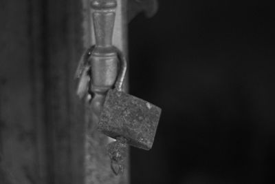 Close-up of rusty metal hanging against wall